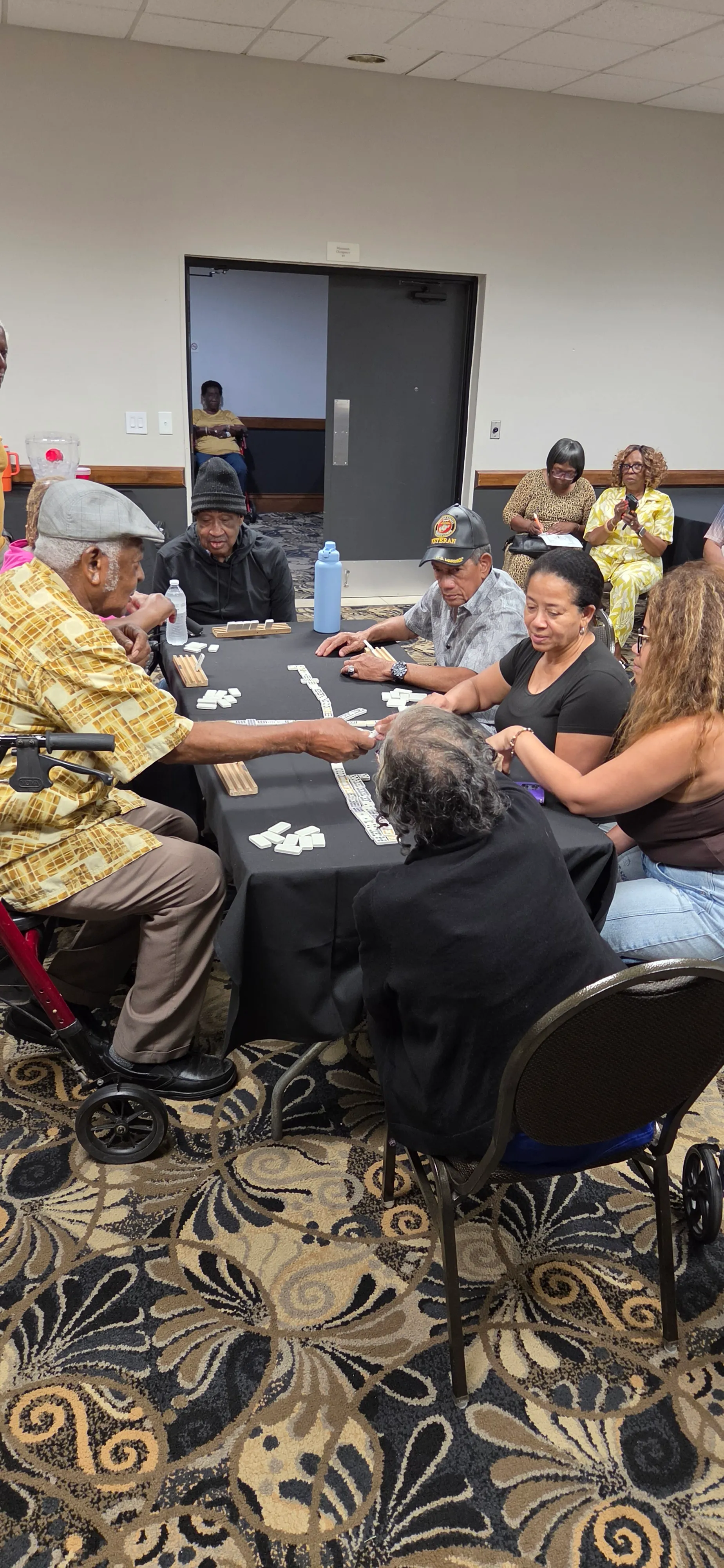 Relatives seated around a game table, playing and laughing together.