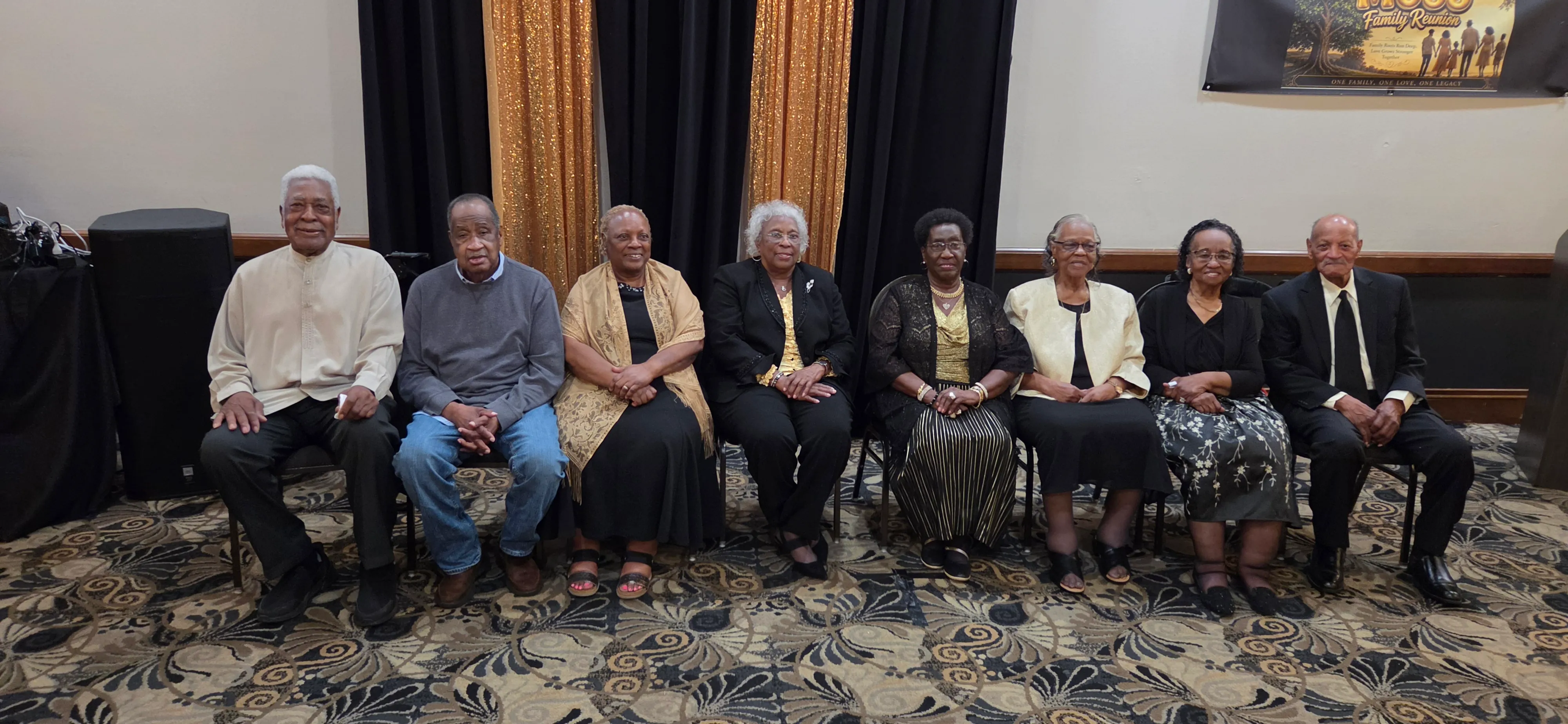 A second photo of the elders seated in a row, dressed in black and cream.